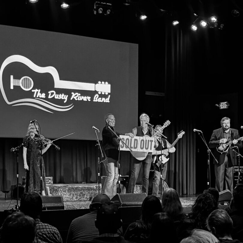 A group of people on stage playing guitar.